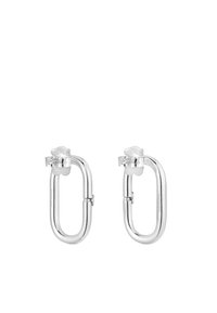 Orecchini in metallo argento a forma ovale geometrica con una finitura liscia. Presentano uno sfondo trasparente per un fissaggio sicuro.