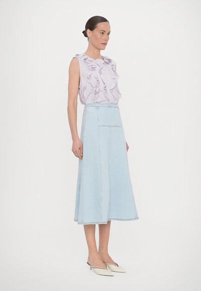 Light purple sleeveless top with ruffled design, paired with a light blue denim A-line skirt. Minimal hardware and smooth texture.
