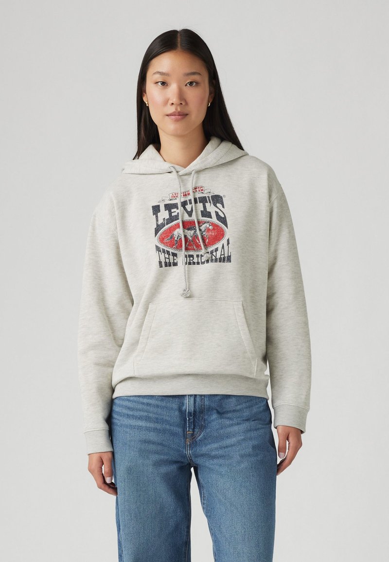 Grå hoodie av mjukt tyg, med en framficka och dragsko i huvan. På bröstet finns en röd och blå Levi's-logotyp.