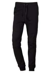 Pantalones de chándal negros hechos de un material suave, con un corte ajustado, cintura elástica con cordones y detalles en panel en los muslos.