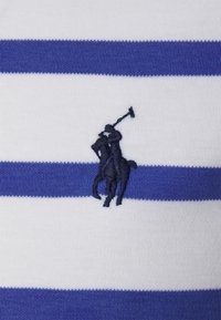 Modrá a bílá pruhovaná polo košile vyrobená z pleteniny, s vyšitým logem hráče póla na koni v námořnické modři.