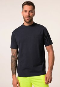 Tyrkysové bavlněné tričko s krátkým rukávem, kulatým výstřihem a kapsičkou na levé straně hrudi. Má hladkou texturu a ležérní design.