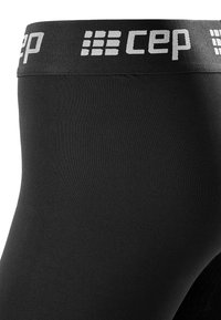 Black compression leggings featuring a textured fabric, wide elastic waistband with "CEP" logo in white, designed for comfort and support.