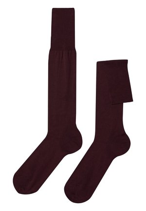 Par de calcetines altos hasta la rodilla de color marrón oscuro, uno completamente extendido y otro doblado en la parte superior, mostrados sobre un fondo blanco.