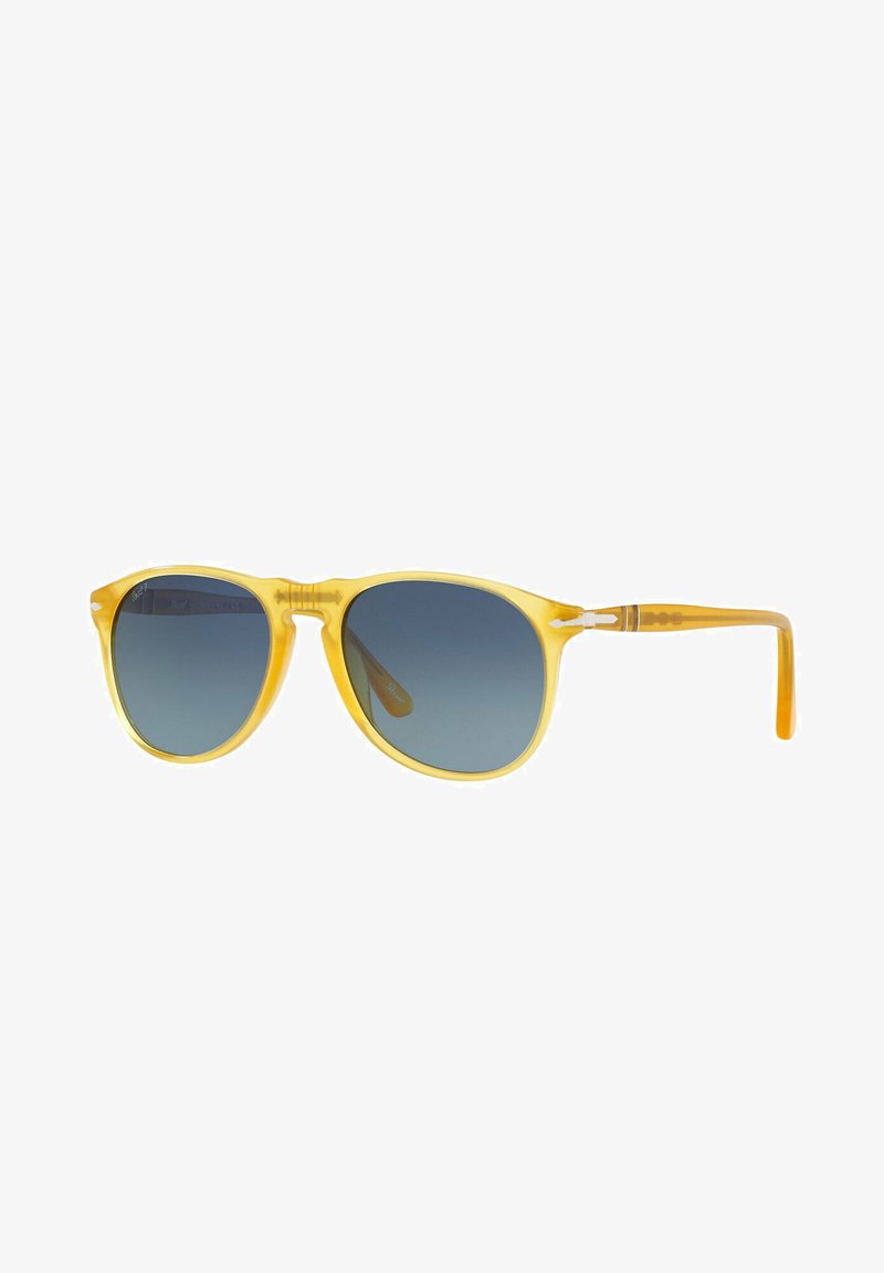 Occhiali da sole in acetato giallo con lenti blu sfumate, montatura leggera e dettagli testurizzati sulle aste. Forma arrotondata con un design classico.