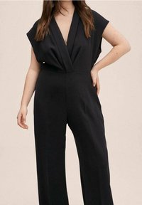 Zwarte jumpsuit met een diepe V-halslijn, korte brede mouwen, een aangesloten taille en wijde pijpen. Zachte stof met een minimale textuur.