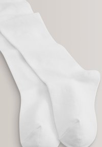 Hvide bomuldsstrømper med en glat tekstur, der har et klassisk design i mellemlang længde og forstærket tåområde. Ingen synlige mønstre eller pynt.