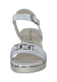 Witte wedge sandaal met een glanzende afwerking, versierd met een decoratieve zilveren ketting, een verstelbare enkelband en een gestructureerde binnenzool.