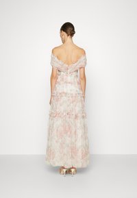 Axelbandslös blommig klänning med volangdetaljer, i mjuka pastellfärger, med en figurnära bodice och flödande kjol, bakre dragkedjestängning.