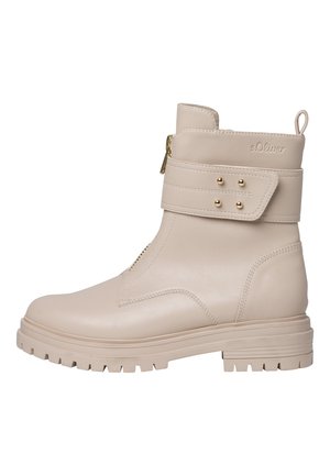 Bottines beiges montantes en cuir lisse, avec une fermeture éclair sur le côté, une sangle ajustable avec des clous dorés et une semelle en caoutchouc texturé.