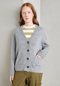 Gray cardigan made of soft knit fabric with a V-neck, six buttons, ribbed cuffs, and two front pockets, layered over a striped shirt.