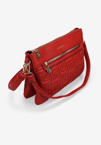 Bolso de mano de cuero rojo con un patrón geométrico texturizado, dos compartimentos con cremallera y un asa desmontable. Accesorios en tono dorado.