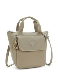 Bolsa tote beige con material texturizado, doble asa, correa de hombro desmontable, bolsillo frontal con solapa y adorno charm.