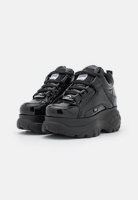 Sorte patenterede lædersneakers med en tyk gummisål, der har sorte snørebånd, teksturerede detaljer og et logo-patch på tungen.