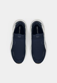 Ναυτικά πλεκτά slip-on αθλητικά παπούτσια με υφή στην επάνω πλευρά, ελαστικό κολάρο και αντίθετη λευκή σόλα. Διαθέτουν ανάγλυφη επωνυμία στο πλάι.