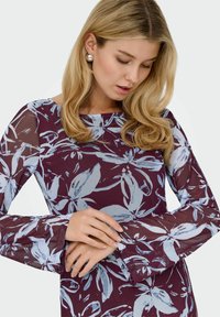 Ilga rankovė suknelė bordo spalvos su šviesiai mėlynų gėlių raštu. Pasižymi permatomomis rankovėmis ir paprastu apvaliu iškirpimu, glotnia tekstūra.