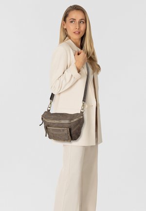 Borsa a tracolla in pelle marrone con superficie testurizzata, chiusura superiore con zip, tasca frontale e dettagli con borchie. Tracolla regolabile per lunghezza personalizzabile.