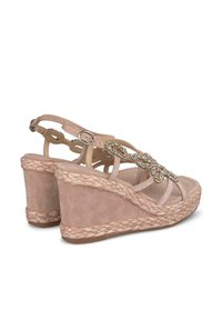 Sandali wedge in morbida suede beige con suola in juta intrecciata. Presentano cinturini decorati con pietre trasparenti e chiusura alla caviglia regolabile.
