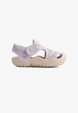 Sandale à motif floral violet avec une semelle épaisse beige, des découpes pour la respirabilité et une bride rembourrée à la cheville, portant le nom de la marque "WHEAT".