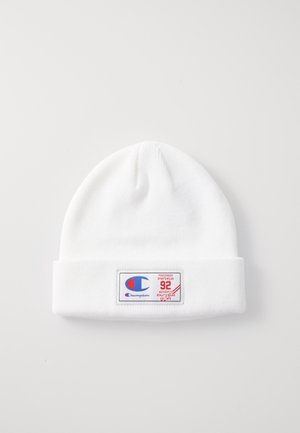 Cappello di lana bianco con risvolto, caratterizzato da un patch logo rettangolare in blu e rosso con il testo: "Champion," "92," e "Authenticated."