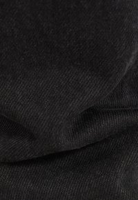 Tela negra con una textura suave, que presenta un patrón de tejido diagonal. La imagen resalta la suavidad del material y su color uniforme.