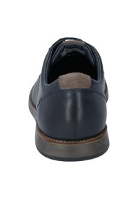 Scarpa in pelle blu con accentuazione in suede sul tallone, pannelli laterali texturizzati e suola in gomma. La vista posteriore mostra il colletto imbottito e i dettagli delle cuciture.