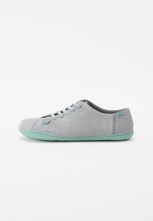 Sneaker in suede grigio con suola in gomma verde menta, punta rotonda, sei occhielli con lacci coordinati e un piccolo etichetta del marchio sul tallone.