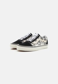 Black suede and patterned canvas sneakers, featuring white laces, a rubber sole, and a detailed paisley design on the upper.