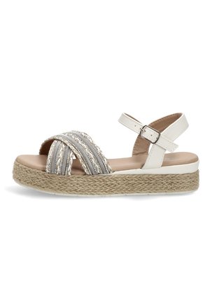 Sandalia de plataforma blanca con suela de yute trenzada, correas delanteras entrelazadas en plata y blanco, y correa ajustable con hebilla en el tobillo.