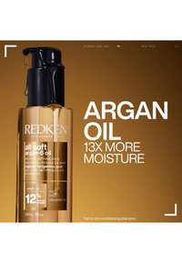 Redken All Soft Argan-6 Oil bottle with drops, promoting argan oil providing 13 times more moisture for dry, brittle hair.