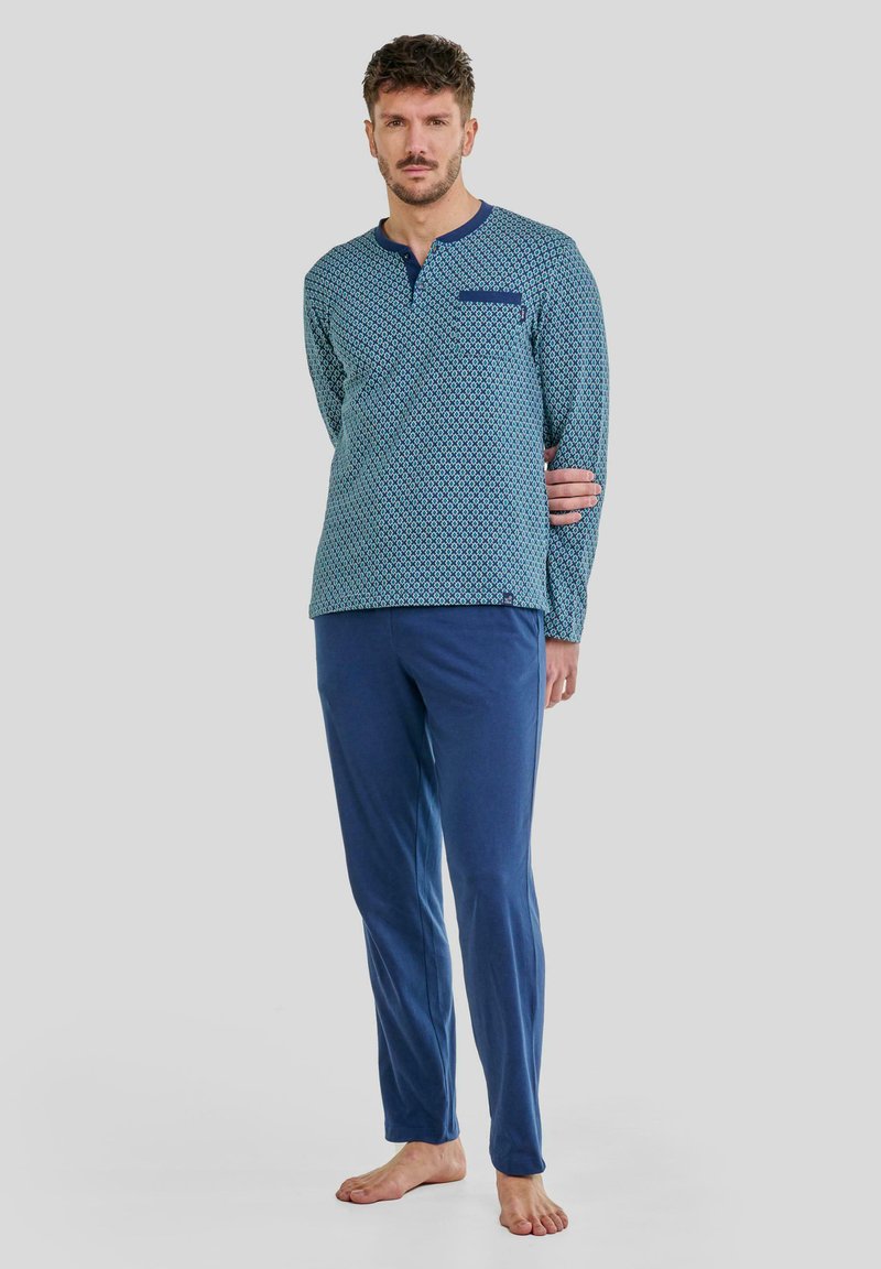 Conjunto de pijama para hombre; parte superior de manga larga en turquesa con un patrón geométrico, pantalones azules, tejido suave y un bolsillo en el pecho.
