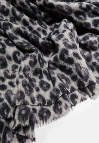 Sciarpa leopardata grigia e nera realizzata in tessuto morbido, con un bordo sfilacciato e una superficie texturizzata.