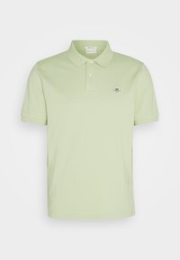 Polo shirt vert clair à manches courtes avec col, deux boutons et petit logo brodé sur la poitrine gauche.
