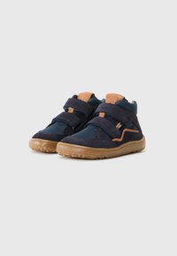 Navyblauwe enkelschoenen van suede en mesh materiaal, met twee verstelbare klittenbandriemen en een tanleren accent op de tong.