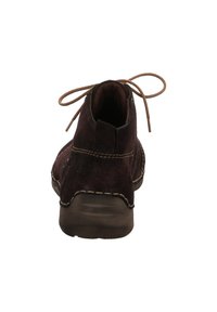 Bottine en suède marron avec un bout arrondi, des coutures beiges et des lacets marron. Le talon est bas et fabriqué dans un matériau durable.