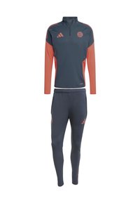 Chándal atlético gris oscuro con acentos naranjas. La parte superior de manga larga cuenta con un media cremallera y un logo, combinada con pantalones ajustados a juego.