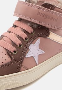 Baskets montantes roses et marron avec une étoile en accent, en matériaux de suède et de cuir, bout rond, fermeture à lacets et sangle Velcro.