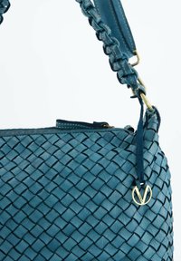 Geweven blauwe leren handtas met een gestructureerd oppervlak, voorzien van een gevlochten strap, gouden hardware details en een ritssluiting.