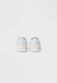 Gaiši pelēki Nike kedas ar zilu akcentu, ar strukturētu augšdaļu, baltu zoli un logotipu uz papēža. Gluda auduma un izturīga konstrukcija.