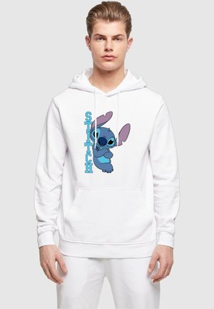 Hvit hettegenser med en blå tegneseriefigur med store ører og uttrykksfulle øyne; designet inkluderer teksten "STITCH" i fet blå skrift.