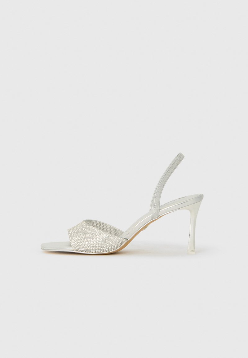Sølvhelede sandaler med en teksturert, glitrende overdel og en smal ankelrem. Har en spiss tå og en klar, høy stilettohæl.