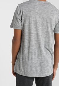 Grå, kortärmad T-shirt med en melerad textur, med rundad halsringning och något förlängd nederkant bak.