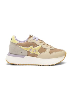 Baskets beige et sable avec étoile jaune et logo "AX", lacets beige et violet, semelle blanche épaisse et col de talon rembourré avec texte.