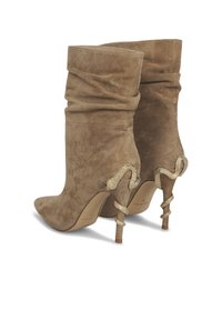 Beige suède enkellaarzen met een slouchy ontwerp, spitse neus en slangenvormige gouden hardware op de hak. Gladde textuur en hoge stilettohak.