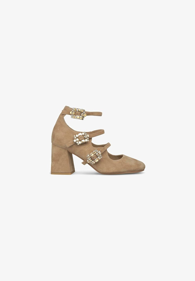 Scarpa con tacco a blocco in suede beige, dotata di tre cinturini alla caviglia, ognuno dei quali presenta delle ornate fibbie rettangolari decorate con pietre trasparenti.