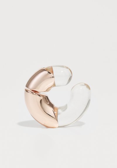 Rose gold and clear acrylic ring featuring a curved, asymmetrical design with smooth, glossy surfaces and contrasting materials.