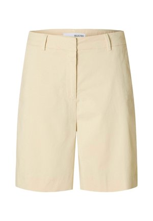 Bēšas kokvilnas šorti ar taisnu griezumu, priekšā rāvējslēdzējs un divām sānu kabatām. Gluda tekstūra un minimālistisks dizains.