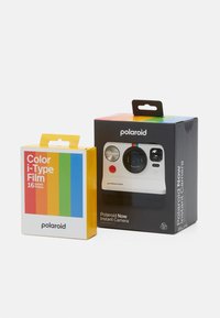 Polaroid Now Instant Camera in white with black accents, featuring a circular lens and two buttons. Color i-Type Film pack in yellow with rainbow stripes.