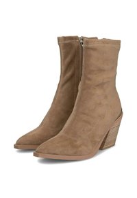 Stivaletti in suede beige con punta appuntita e tacco affusolato. Presentano una zip laterale e cuciture a vista lungo le giunture.