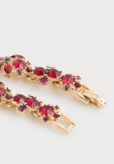 Zlatý náramek s červenými a fialovými drahokamy uspořádanými v shlucích, s přezkou gravírovanou nápisem "MARCHESA."